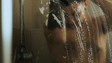 Mann unter Dusche Fitnesspark