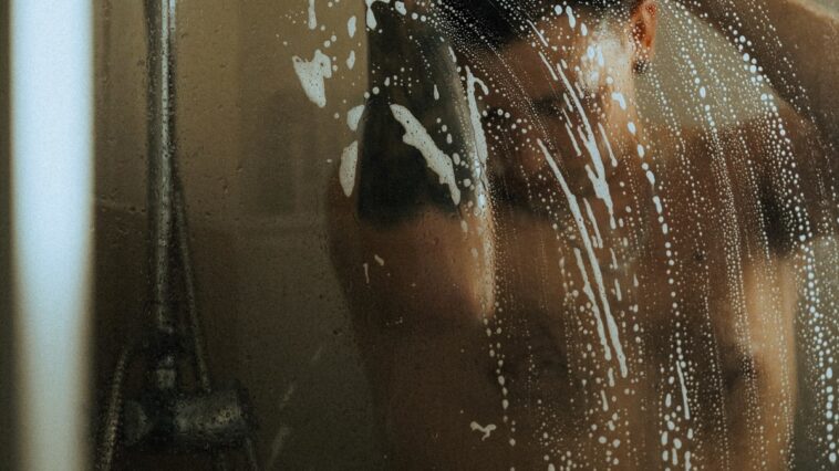 Mann unter Dusche Fitnesspark